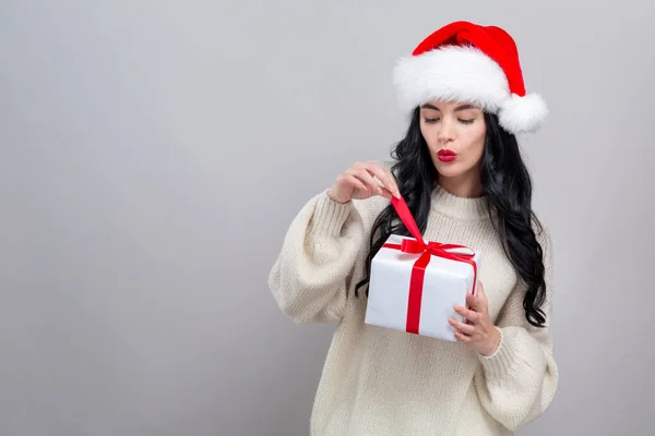 Giovane donna con cappello di Babbo Natale in possesso di una scatola regalo — Foto Stock