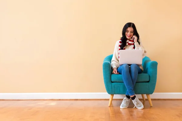 Jeune femme avec un ordinateur portable dans une pose réfléchie — Photo
