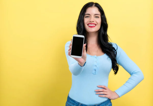 Jonge vrouw stak een telefoon in haar hand — Stockfoto