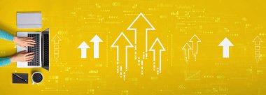 Bir dizüstü bilgisayar kullanan kişi ile yükselen ok teması