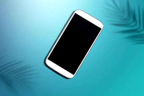 Smartphone s tropickými palmovými listy a stínem — Stock fotografie