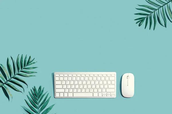 Computertoetsenbord en muis met tropische planten — Stockfoto