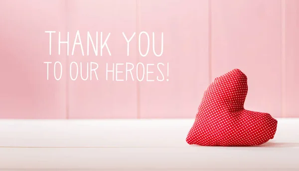 Merci à notre message Heroes avec un coussin coeur rouge — Photo