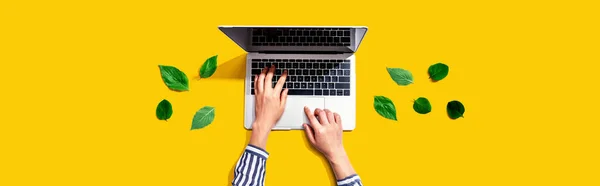Persoon met een laptop met groene bladeren — Stockfoto