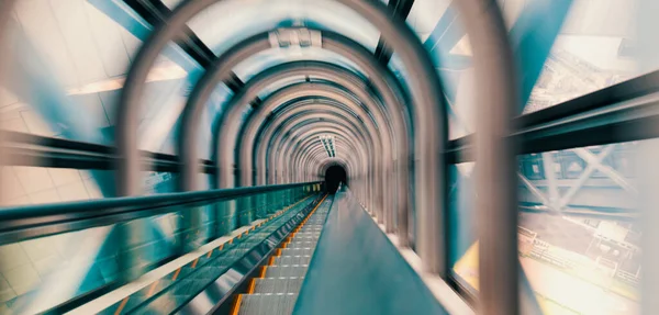 강렬 한 움직임은 에스컬레이터 터널을 통해 희미하게 보인다 — 스톡 사진