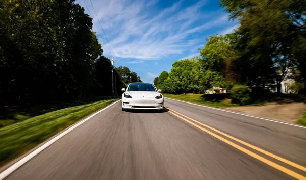 Yeni bir Tesla Model 3 tamamen elektrikli araba yolda ilerliyor. — Stok fotoğraf