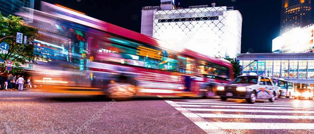 People and traffic cross the famous scramble intersection in Shibuya, Tokyo, Japan