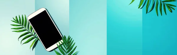 Smartphone met tropische palmbladeren — Stockfoto