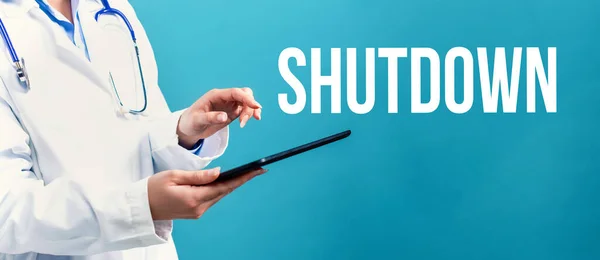 Shutdown theme with a doctor using a tablet — Stock Photo, Image