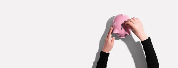 Pessoa que deposita dinheiro num banco porquinho — Fotografia de Stock