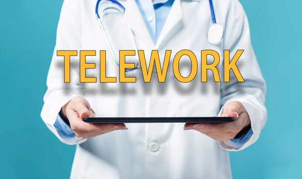 Tema do teletrabalho com um médico usando um tablet pc — Fotografia de Stock