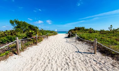 Beyaz kumlu bir sahile giriş.