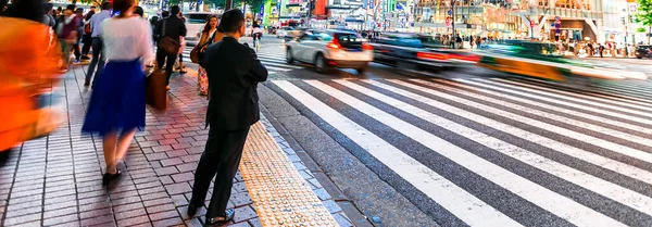 東京都渋谷区の有名なスクランブル交差点を横断する人々と交通 — ストック写真