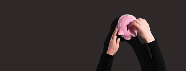 Человек, кладущий деньги в копилку