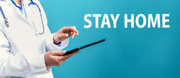 Stay home theme with a doctor using a tablet — Stock Photo, Image