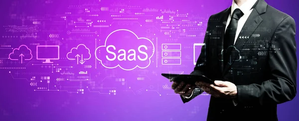 SaaS - oprogramowanie jako koncepcja serwisu z biznesmenem korzystającym z tabletu — Zdjęcie stockowe