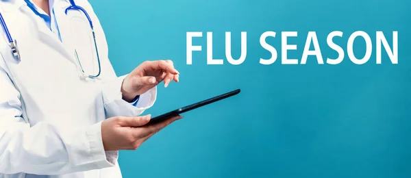 Tema da estação da gripe com um médico usando um tablet — Fotografia de Stock