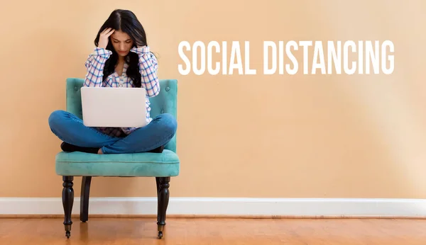 Social Distanciamento tema com uma jovem mulher sentada com seu laptop — Fotografia de Stock