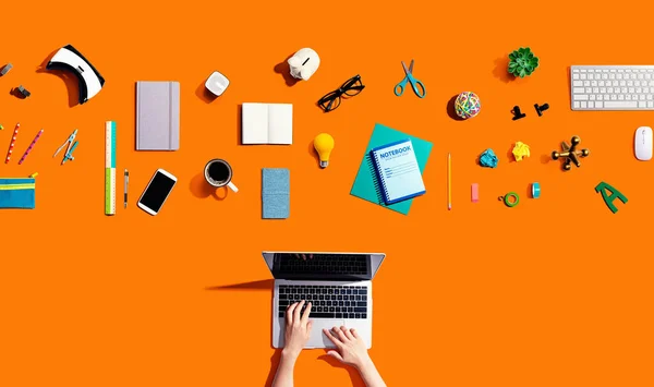 Person, die einen Laptop mit Büromaterial benutzt — Stockfoto