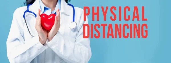 Tema de distanciamiento físico con un médico sosteniendo un corazón — Foto de Stock