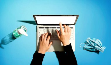 El dezenfektanı ve maskeli dizüstü bilgisayar.