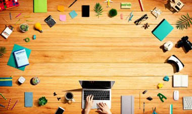 Ofis malzemesi olan bir dizüstü bilgisayar kullanan kişi.