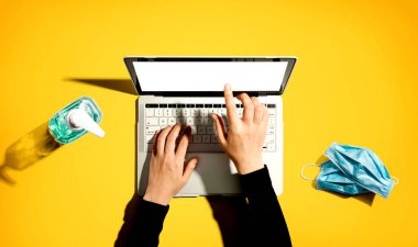 El dezenfektanı ve maskeli dizüstü bilgisayar.