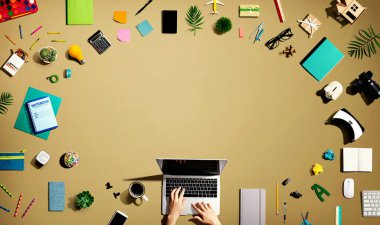 Ofis malzemesi olan bir dizüstü bilgisayar kullanan kişi.