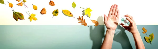 Applying sanitizer gel with autumn leaves — Stock Photo, Image