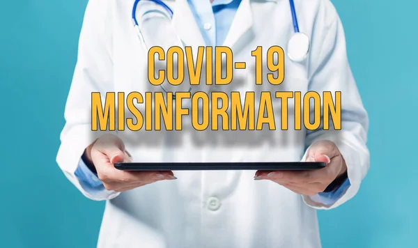 Covid-19 Θέμα παραπληροφόρησης με ένα γιατρό που χρησιμοποιεί ένα tablet pc — Φωτογραφία Αρχείου