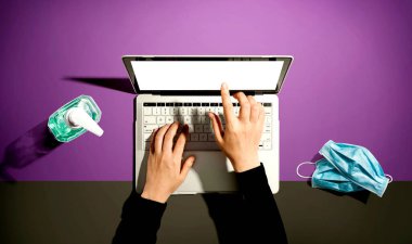 El dezenfektanı ve maskeli dizüstü bilgisayar.