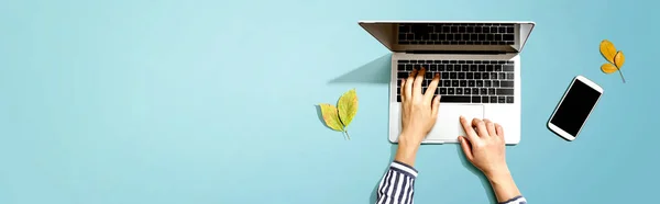 Őszi levelek személy segítségével egy laptop számítógép — Stock Fotó
