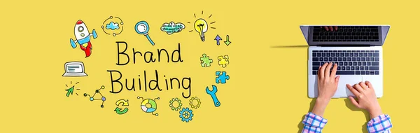 Brand building con donna utilizzando un computer portatile — Foto Stock