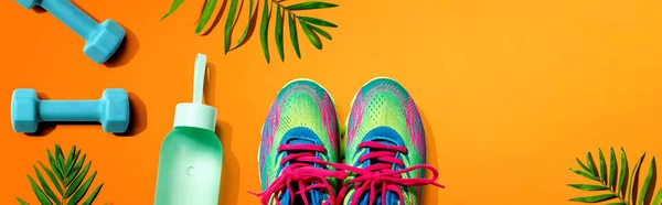 Scarpe fitness e manubri con piante tropicali — Foto Stock