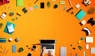 Ofis malzemesi olan bir dizüstü bilgisayar kullanan kişi.