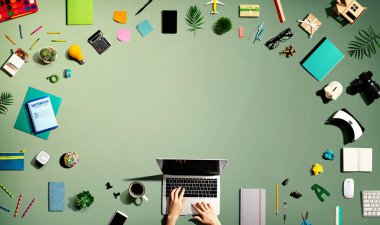 Ofis malzemesi olan bir dizüstü bilgisayar kullanan kişi.