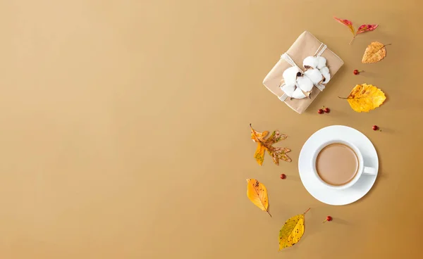 Herbstthema mit einer Tasse Kaffee und einer Geschenkbox — Stockfoto