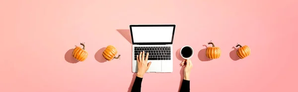 Herfst pompoenen met persoon met behulp van een laptop — Stockfoto