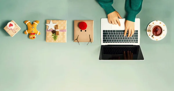 Weihnachtsgeschenkboxen mit einer Person, die einen Laptop benutzt — Stockfoto