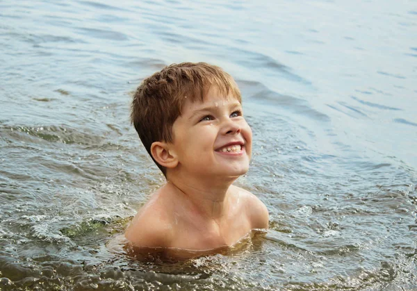 Happy boy swimming in a river