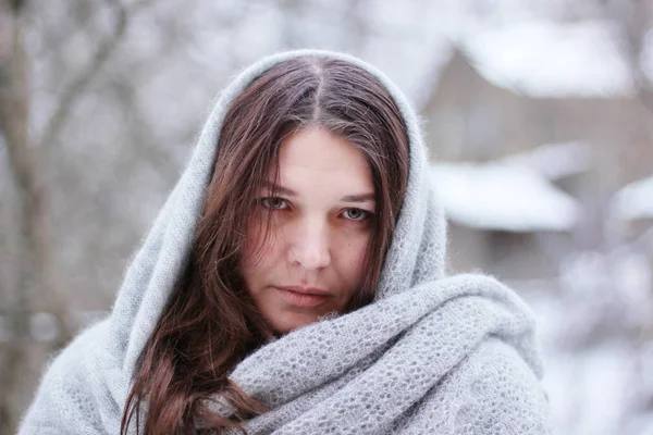 beautiful young woman with big scarf in winter park