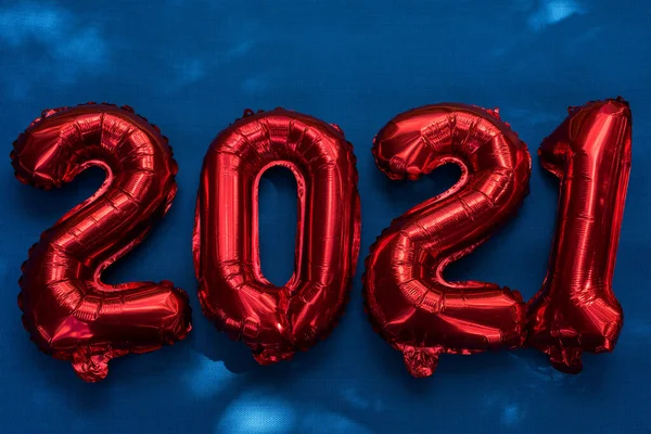 figures 2021 from balloons on blue background, the concept of new year and Christmas