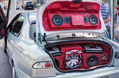 power music audio system with amplifiers, bass and treble speakers in the car trunk exhibited at rally Fashion tuning club, on August 12, 2012 in Borghi, RN, Italy clipart