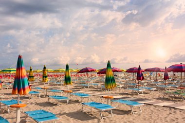 plaj şemsiye ve şezlong altında bir bulutlu gökyüzü - şafak vakti ıssız bir banyo ile  