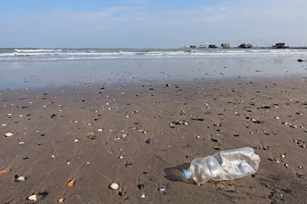 Plastik şişe çöp sahilde - manzara ile Balık tutma kulübe arka plan üzerinde bir Seaside