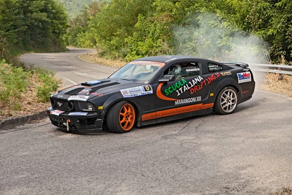 a drift racing car Ford Mustang in action with smoking tires in hairpin bend at Rally della Romagna 2013, on July 28, 2013 in Dovadola, FC, Italy