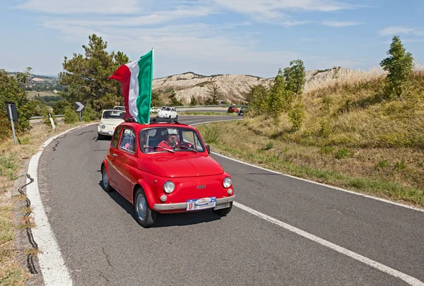 ビンテージ小型車集会リミニ イタリアの 2013 トロフェオ ロレンツォ バンディーニ でイタリアの旗と赤い車が率いるフィアット 500 — ストック写真