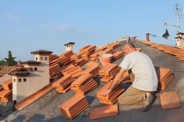 Çatı: İnşaat işçisi üzerinde bir çatı fayans - çatı yenileme ile kaplama: katranlı kağıt, yeni karo ve baca yüklenmesini 