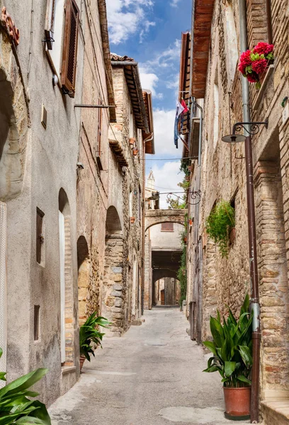 古代アーチ 地下道 ベヴァーニャ イタリア ウンブリア州の花と絵のような狭い路地 — ストック写真