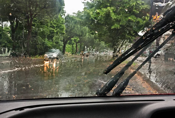 在雨中驾驶汽车 通过湿挡风玻璃查看道路 — 图库照片